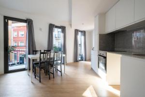 cocina y comedor con mesa y sillas en Centric Apartment Camp Nou, en Hospitalet de Llobregat
