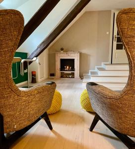 a living room with two chairs and a fireplace at Ferienhaus Tante Elses - Ruhe & Erholung zwischen den Meeren - gemütliche & stilvolle Ausstattung in Süderhöft