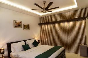 a bedroom with a bed with a ceiling fan at Williams Park Suite in Bangalore