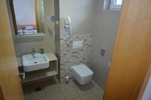 een badkamer met een wastafel, een toilet en een douche bij APARTMA My HILL 5 in Maribor