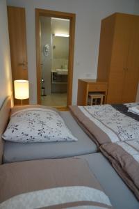ein Schlafzimmer mit 2 Betten und ein Badezimmer mit einem Spiegel in der Unterkunft APARTMA My HILL 5 in Maribor