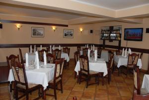 a dining room with tables and chairs with white tablecloths at Pensiunea Turistica Europa in Drobeta-Turnu Severin