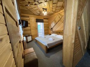 ein Schlafzimmer mit einem Bett in einer Holzhütte in der Unterkunft Rich OAK - Багатий Дуб in Jablunyzja