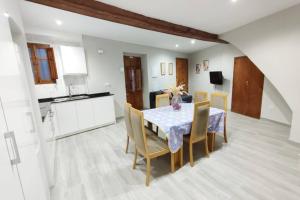 uma cozinha e sala de jantar com mesa e cadeiras em Acogedora casa en Llíria em Llíria