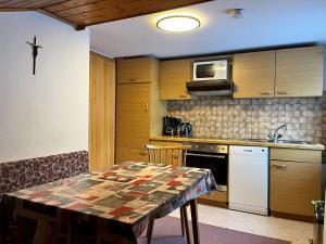 eine Küche mit einem Tisch und einer Mikrowelle in der Unterkunft Apartment Wiesenhof - LFD200 by Interhome in Längenfeld
