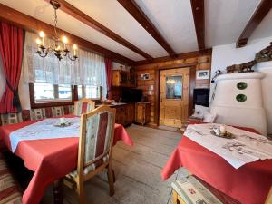 ein Esszimmer mit einem roten Tisch und einer Küche in der Unterkunft Apartment Wiesenhof - LFD201 by Interhome in Längenfeld