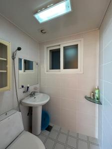 a white bathroom with a sink and a toilet at Sunset Hanok Stay in Suncheon