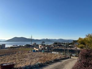 a dirt road next to the ocean with houses at Sunset Hanok Stay in Suncheon