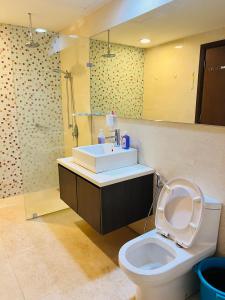 a bathroom with a toilet and a sink and a mirror at Regalia Spritz Empire Hostel in Kuala Lumpur