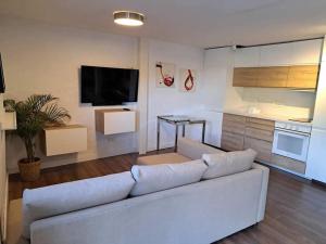 sala de estar con sofá blanco y cocina en Casita Tolox en Tolox