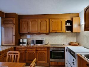 eine Küche mit Holzschränken und einer Arbeitsplatte in der Unterkunft Apartment Monika - KPL562 by Interhome in Kappl