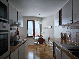 a kitchen with a table and a dining room at Family penthouse with great view in Garðabær
