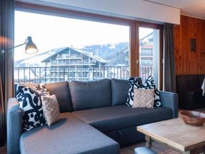 a living room with a couch and a large window at Apartment Christiania I F4 by Interhome in Nendaz