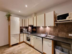 een keuken met witte kasten en een wastafel bij Apartment Apart Birgit - KPL175 by Interhome in Kappl