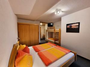 1 dormitorio con 2 camas con almohadas de color naranja y amarillo en Apartment Apart Birgit - KPL175 by Interhome, en Kappl