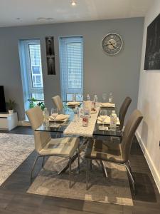 une salle à manger avec une table, des chaises et une horloge dans l'établissement ABBA Views, à Londres