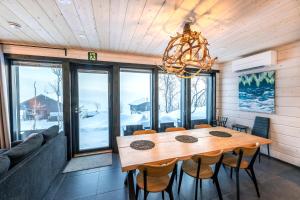 uma sala de jantar com uma mesa de madeira e cadeiras em Korppi Mökki em Kilpisjärvi