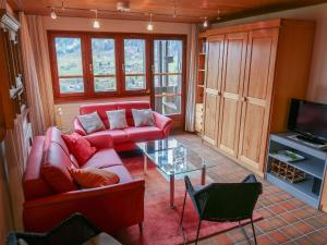 a living room with a red couch and a glass table at Apartment Aragon T100 by Interhome in Fiesch +69 photos