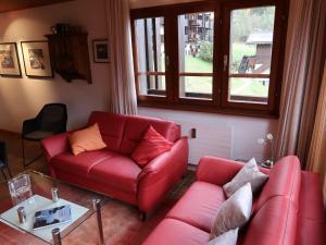 - un salon avec deux canapés rouges et une fenêtre dans l'établissement Apartment Aragon T100 by Interhome, à Fiesch