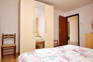 1 dormitorio con cama y espejo en Apartments Car Lj., en Šilo