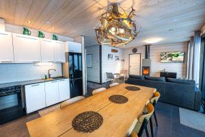 una cucina e una sala da pranzo con tavolo in legno in una stanza di Korppi Mökki a Kilpisjärvi