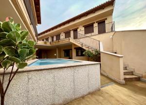 a house with a swimming pool in a courtyard at Hostería La milla Rural in Guadapero