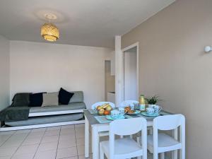 La Parée PreneauにあるHoliday Home Hameau Océan - SHR100 by Interhomeのリビングルーム(テーブル、椅子、ベッド付)