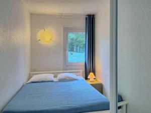 a bedroom with a blue bed and a window at Holiday Home Hameau Océan - SHR101 by Interhome in La Parée Preneau