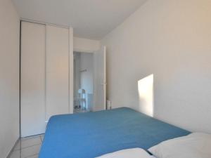 a bedroom with a blue bed and a white wall at Holiday Home Hameau Océan - SHR101 by Interhome in La Parée Preneau