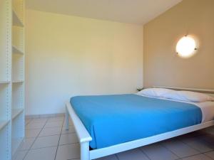La Parée PreneauにあるHoliday Home Hameau Océan - SHR102 by Interhomeのベッドルーム(青いベッド1台、棚付)