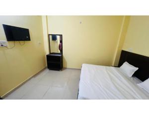 a hotel room with a bed and a television at Hotel Sadguru Inn, varanasi in Varanasi