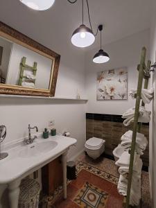 ein Badezimmer mit einem Waschbecken, einem WC und einem Spiegel in der Unterkunft La Scalinata in Bordighera