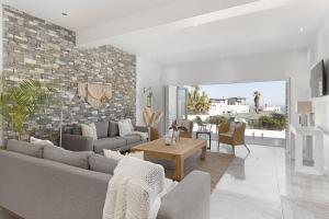 uma sala de estar com um sofá e uma mesa em Endless Summer Beach House em Bloubergstrand