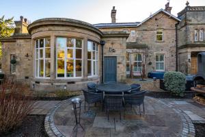 Casa con patio con mesa y sillas en 6* Royal Garden Suite Private Island Lake District, en Caton