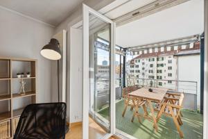 een eetkamer met een tafel en een balkon bij Dohlenweg 2 in Zürich