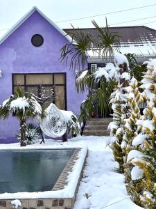 a purple house with a swimming pool in the snow at AkbA-Frame3 in İsmayıllı