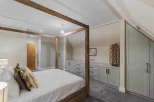 - une chambre avec un grand lit et un cadre en bois dans l'établissement 3BR Retreat, Allocated Parking, Private Garden, à Windsor