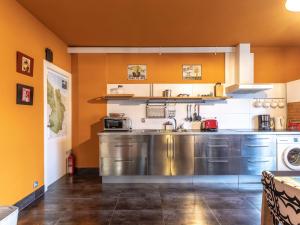 cocina con paredes de color naranja y electrodomésticos de acero inoxidable en Apartment Urdaibai by Interhome, en Altamira