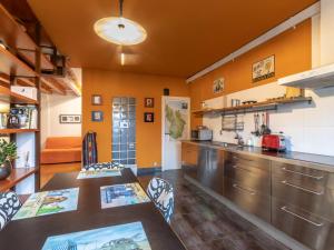 cocina con paredes de color naranja y electrodomésticos de acero inoxidable en Apartment Urdaibai by Interhome, en Altamira