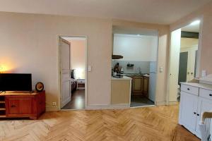 an empty living room with a kitchen and a television at Le Spacieux du Centre in Agen