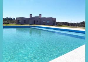 una gran piscina frente a una casa en Casa barrio cerrado Las Lomas en Monte Hermoso