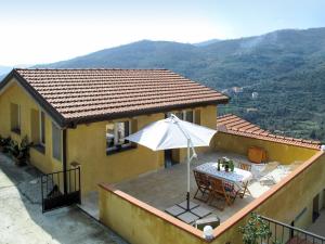 a house with a table and an umbrella on a balcony at Apartment Adriana - PRE170 by Interhome in Valloria