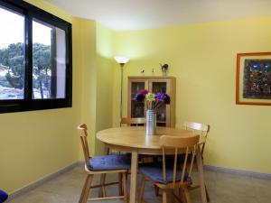 a dining room table with chairs and a vase of flowers at Apartment Escorxador by Interhome in L'Escala +13 photos