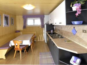 uma cozinha com uma mesa e uma sala de jantar em Apartment Deluca - PFS466 by Interhome em Pozza di Fassa