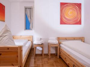 サンモリッツにあるアパートメント 30のベッド2台が備わる客室で、壁には絵画が飾られています。