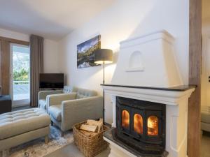 a living room with a fireplace and a couch at Holiday Home Steindlwald by Interhome in Untertauern