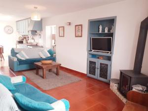 uma sala de estar com um sofá azul e uma televisão em Coja Flores Beautiful River Beaches & Mountains em Coja