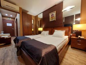 ein Schlafzimmer mit einem großen Bett in einem Zimmer in der Unterkunft Hotel City Pleven in Plewen