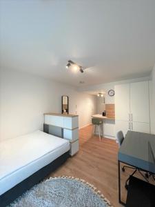 een slaapkamer met een bed, een bureau en een tafel bij helloYOU Apartments in Ingelheim am Rhein