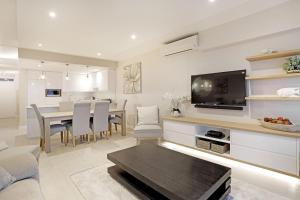 a living room with a table and a dining room at Dolphin Beach H106 by HostAgents in Bloubergstrand
